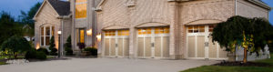 tan garage doors with white trim on brick house